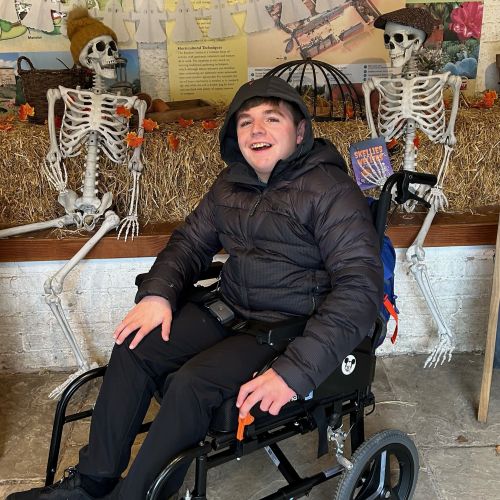 Cody riding on his adapted trike on the beachfront